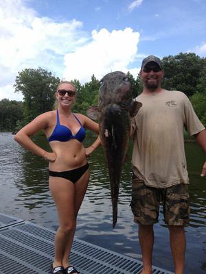 Cute girl with her noodling catfish. 
