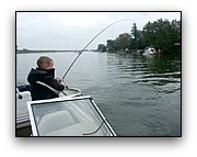 Kid fishing on a boat, beginner child catching fish in a coat jacket, cold weather. Kid fishing on a boat, beginner child catching fish in a coat jacket, cold weather.